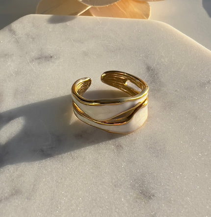 Gold and white cuff bracelet on a marble surface