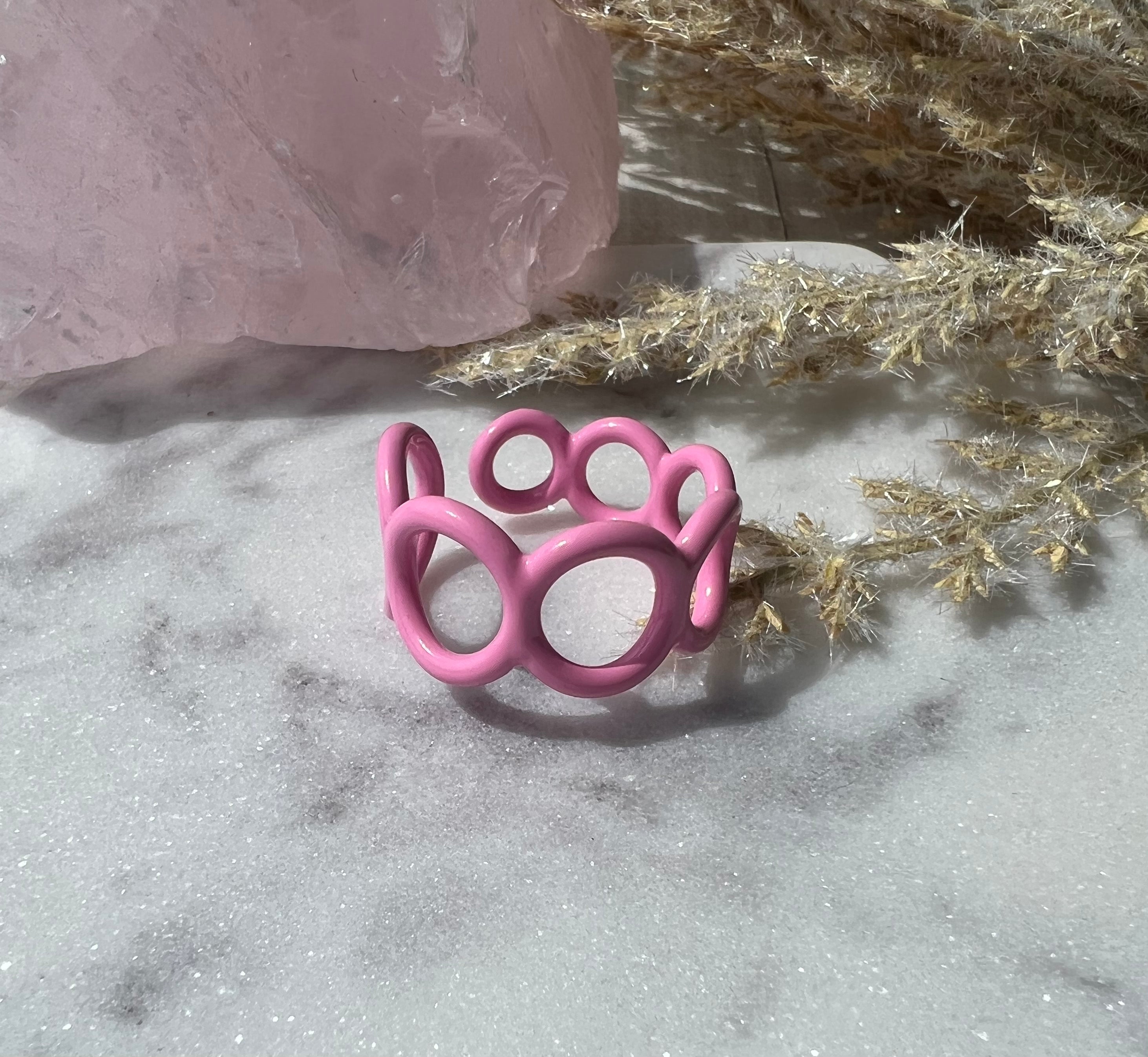 Pink colored enamel ring with small circle cut outs adjustable in size