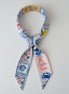 Decorative scarf with colorful patterns and text on a white background