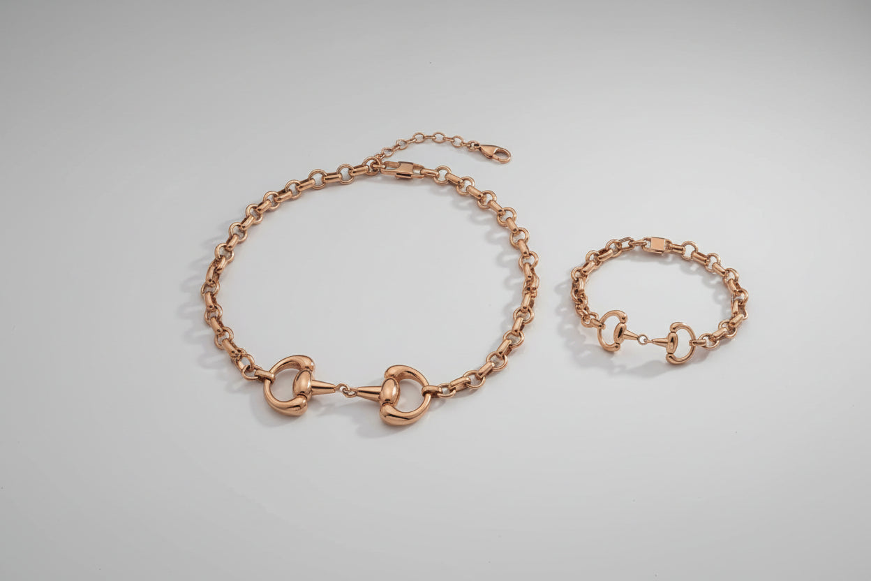 Gold horse bit necklace and matching bracelet on a white background