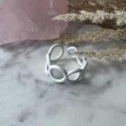 White colored enamel ring with small circle cut outs adjustable in size