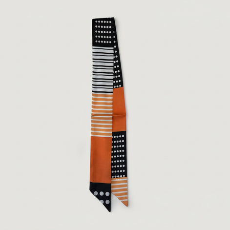 Scarf with black, white, and orange pattern on a white background