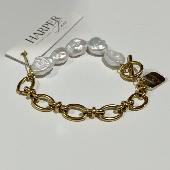 Gold bracelet with pearls on a white background