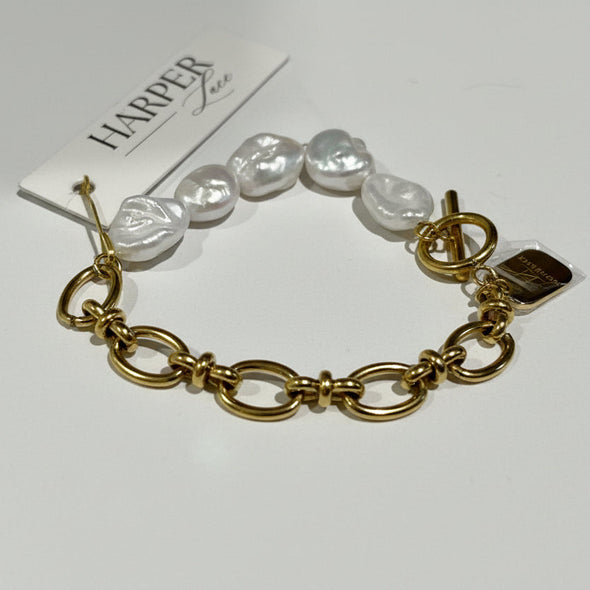 Gold bracelet with pearls on a white background