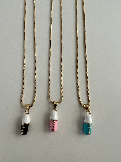 three separate gold chain pendants holding a pink, tiffany blue and black colored pill charm with the word chill written in gold letters on the pill charm