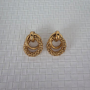 Pair of gold hoop earrings on a textured gray surface