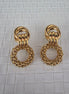 Pair of gold earrings on a textured white background