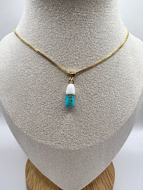 gold chain pendant holding a tiffany blue colored pill charm with the word chill written in gold letters on the pill charm