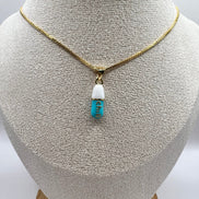 gold chain pendant holding a tiffany blue colored pill charm with the word chill written in gold letters on the pill charm