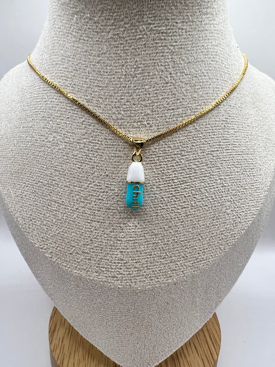 gold chain pendant holding a tiffany blue colored pill charm with the word chill written in gold letters on the pill charm