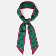 Green and red polka dot ribbon on a white background