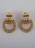 Pair of gold hoop earrings on a textured white background