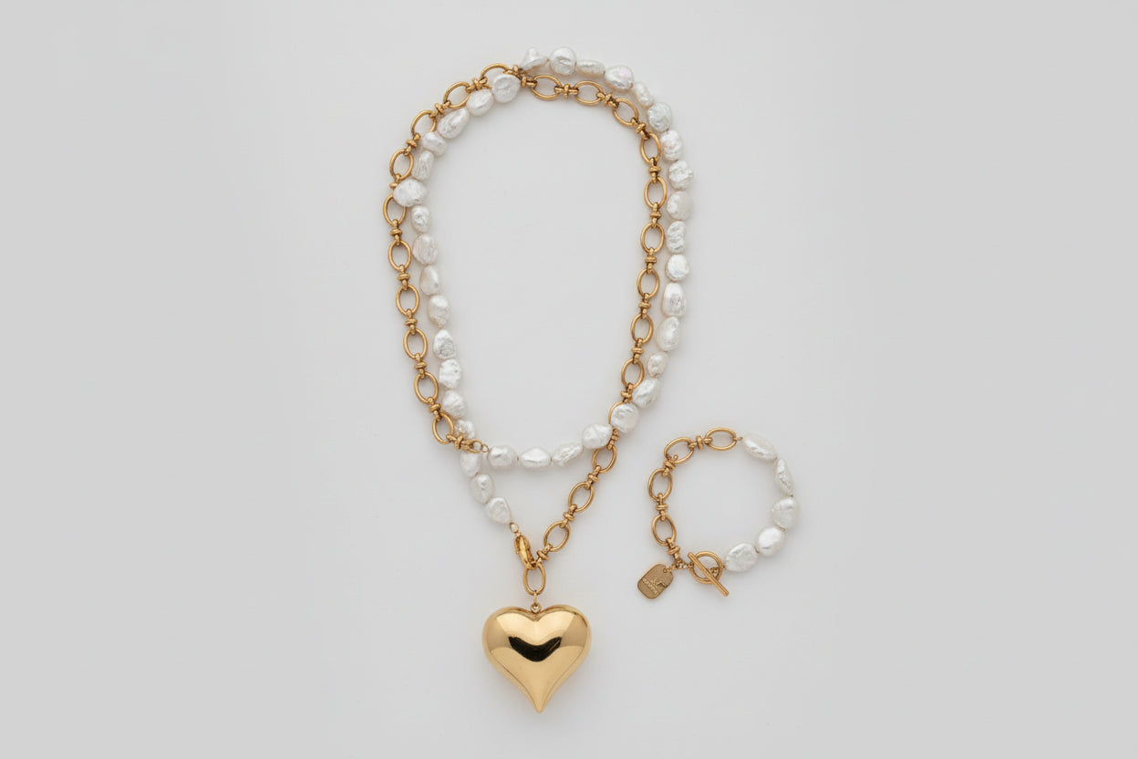 Necklace and bracelet set with heart pendant on a textured surface