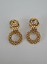 Pair of gold earrings on a textured white background