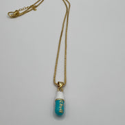 gold chain pendant holding a tiffany blue colored pill charm with the word chill written in gold letters on the pill charm
