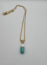 gold chain pendant holding a tiffany blue colored pill charm with the word chill written in gold letters on the pill charm