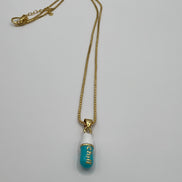 gold chain pendant holding a tiffany blue colored pill charm with the word chill written in gold letters on the pill charm