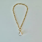 A gold chain pendant necklace with a pearl drop pendant.