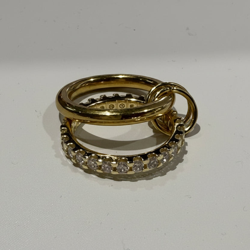 Two gold rings with diamond accents on a white background