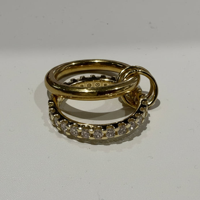 Two gold rings with diamond accents on a white background