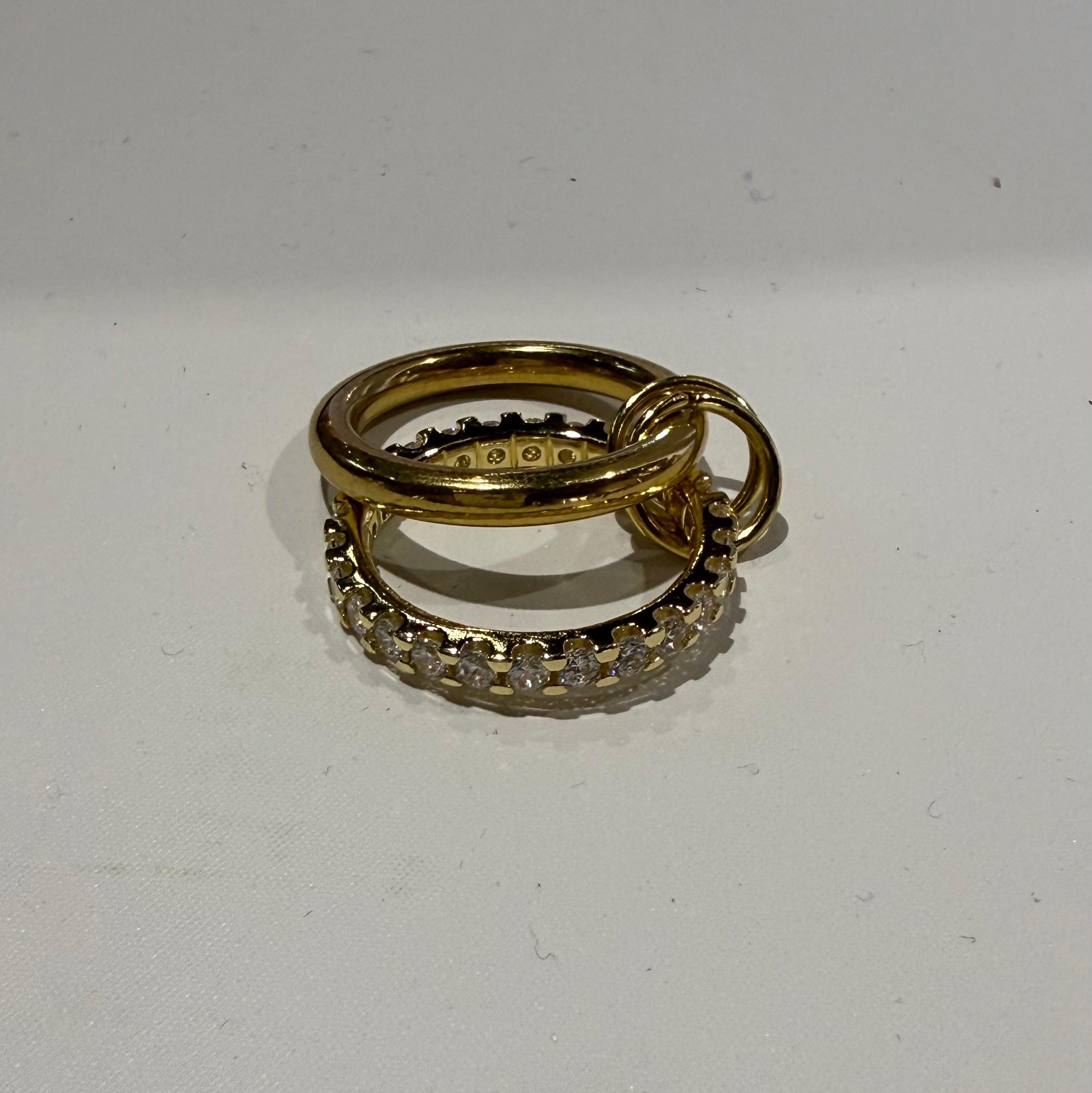 Two gold rings with diamond accents on a white background