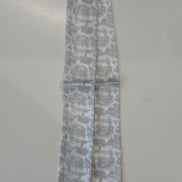 Greige floral toile patterned fabric strips on a white plate