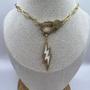 14K gold filled paperclip chain pendant necklace with a micro pave gold lobster clasp that holds a white enamel lightning bolt charm with micro pave accents