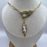14K gold filled paperclip chain pendant necklace with a micro pave gold lobster clasp that holds a white enamel lightning bolt charm with micro pave accents