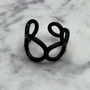Black colored enamel ring with small circle cut outs adjustable in size