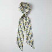Scarf with lemon pattern and thin black stripes on a white background