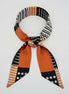 Scarf with black, white, and orange pattern on a white background