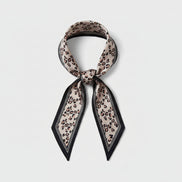 Beige leopard print scarf with black border on a white background