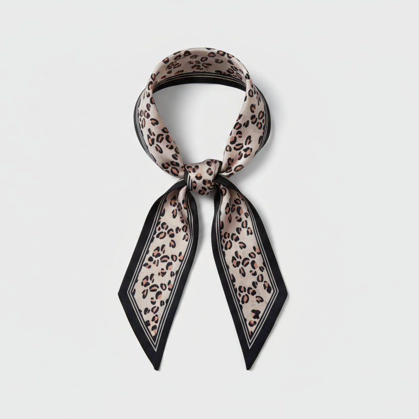 Beige leopard print scarf with black border on a white background