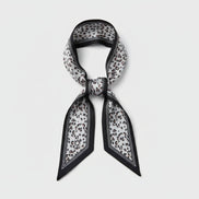 Scarf with black vertical lines with a beige and black leopard print design on a white background