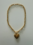 An 18k gold stainless steel scalloped heart necklace with a gold chain and a gold heart-shaped pendant.