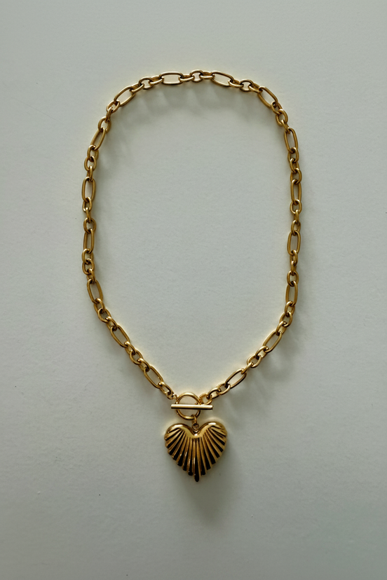 An 18k gold stainless steel scalloped heart necklace with a gold chain and a gold heart-shaped pendant.