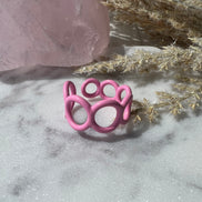 Pink colored enamel ring with small circle cut outs adjustable in size