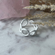 White colored enamel ring with small circle cut outs adjustable in size