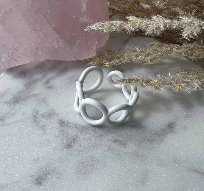 White colored enamel ring with small circle cut outs adjustable in size