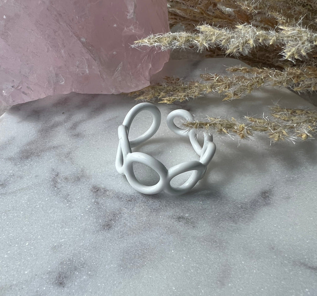 White colored enamel ring with small circle cut outs adjustable in size
